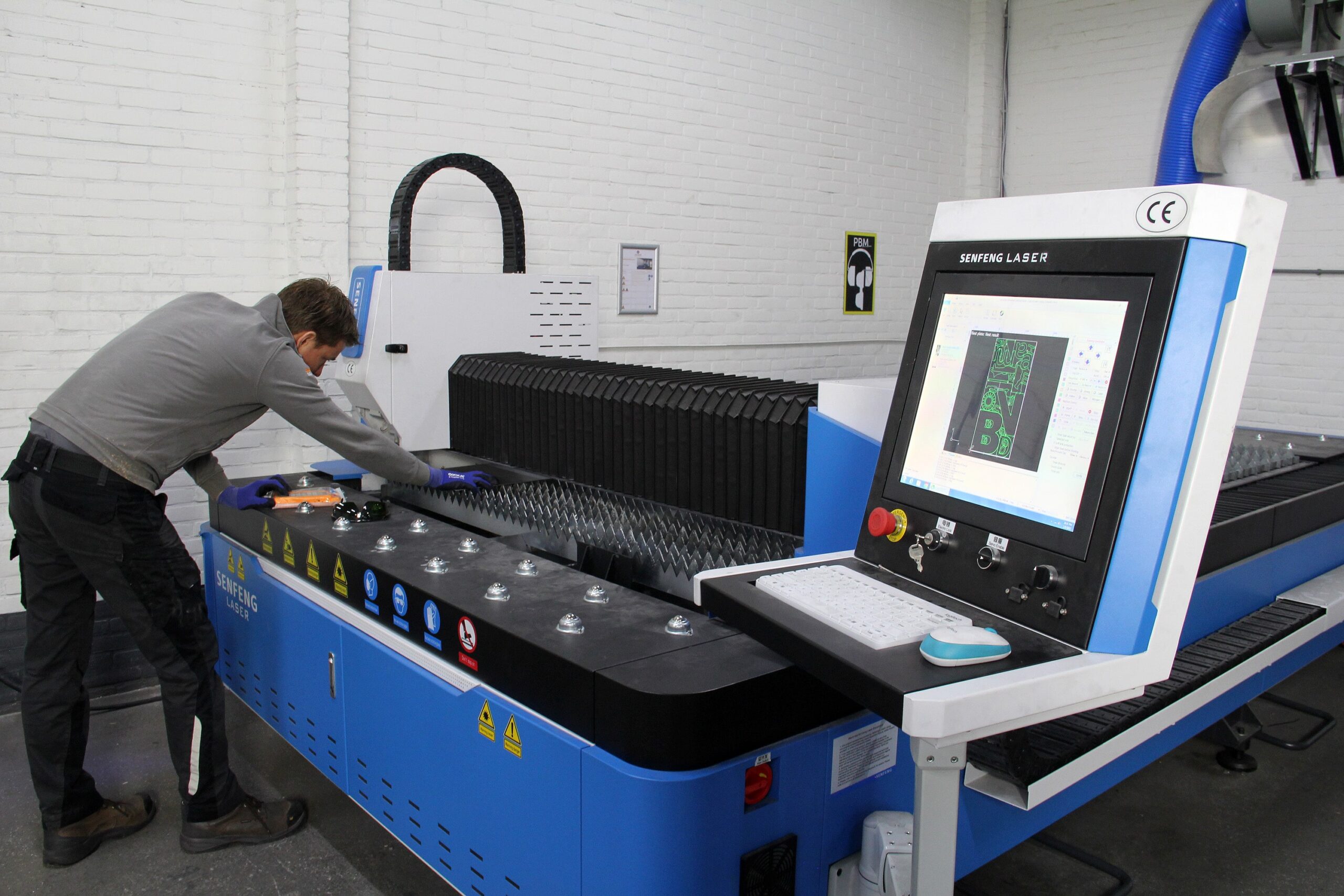 Een medewerker aan het werk met de lasermachine.