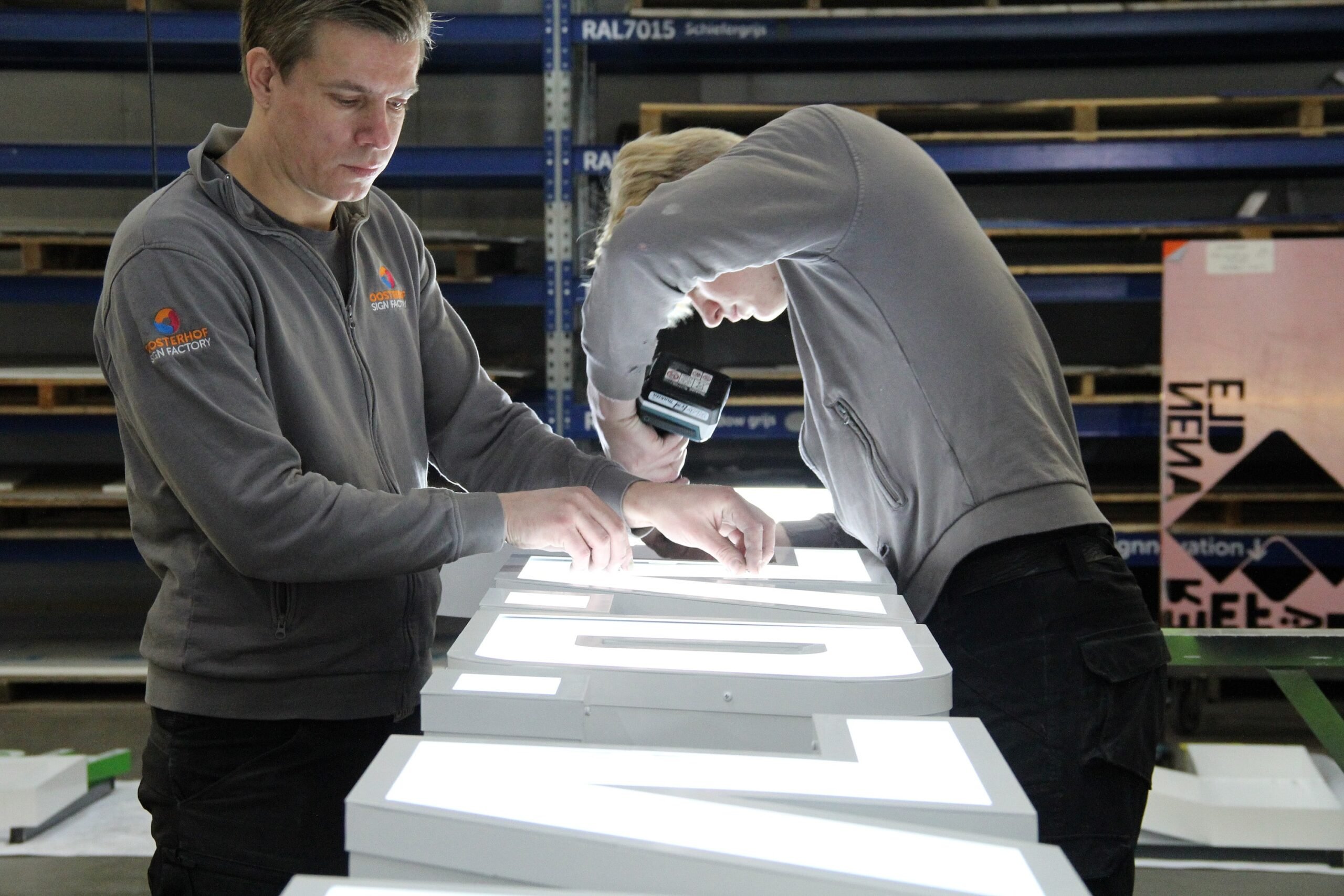 Twee medewerkers bezig met het assembleren van het product.